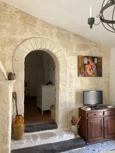 a living room with an archway with a tv and a table at Villa Sara di Puglia in Castellaneta