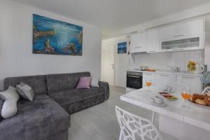 a living room with a couch and a table at Hortenzija Apartments in Makarska