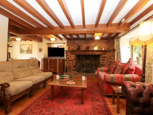 a living room with couches and a fireplace at Shells Cottage in Washford