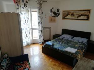 een kleine slaapkamer met een bed en een raam bij Comfortable and Friendly Apartment in Trieste