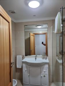 uma casa de banho com um lavatório e um espelho grande em Suncoast Residence V (Free parking) no Funchal