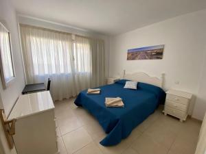 sypialnia z niebieskim łóżkiem i niebieskim kocem w obiekcie Nice rooms in a shared apartment in the centre of Corralejo Habitaciones en piso compartido w Corralejo