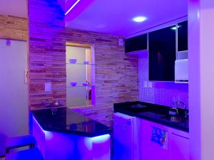 a kitchen with purple lights in a room at Biarritz temporadalitoranea in São Luís +80 photos