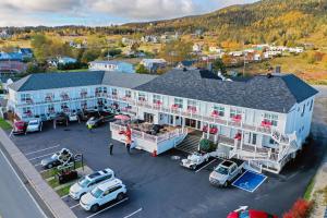 an aerial view of a large white building with cars parked in a parking lot at Hotel Motel Manoir de Percé in Perce