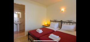 a bedroom with a red bed with two white pillows at Mirabella Vista in Agios Nikolaos