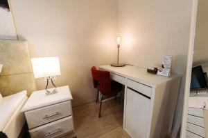 1 dormitorio con escritorio con lámpara y silla en City Apartments - Junior suite room en Smolensk