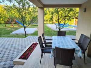une terrasse avec une table et des chaises ainsi qu'une aire de jeux dans l'établissement Oasis of peace, à Bihać