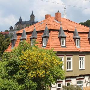 a building with an orange roof and a tree at Villa Schlossblick I - Zeit zum Entspannen in exklusiver Ferienwohnung mit Panoramablick, Parkplatz, WLAN, Smart-TV in Wernigerode