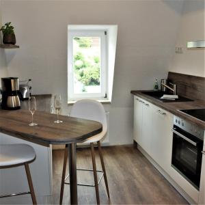 eine Küche mit einem Tisch und Stühlen sowie einem Fenster in der Unterkunft Villa Schlossblick in Wernigerode