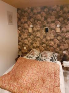 ein Schlafzimmer mit einer Holzwand in der Unterkunft Maison authentique en pierre apparente en montagne dans le c antal in Thiézac