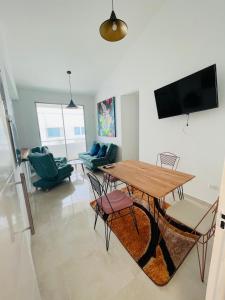 een woonkamer met een houten tafel en stoelen bij Apartamento Coveñas Deluxe in Coveñas