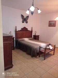 1 dormitorio con 1 cama con mariposas en la pared en Hostal el Hayedo, en Cantalojas