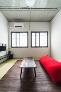 een kamer met een rode bank en een tafel bij Oyado danran 団欒 in Tokyo