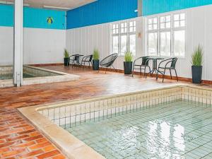 a swimming pool with tables and chairs in a room at Holiday home Højer VIII in Højer