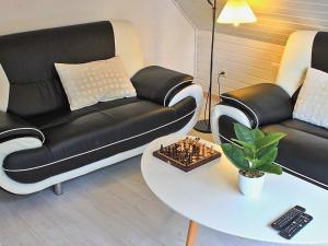 Fjand Gårdeにある6 person holiday home in Ulfborgのリビングルーム(黒いソファ、テーブル付)