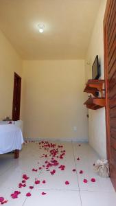 Habitación con pétalos de rosa en el suelo en Suíte das flores em Guajiru, en Trairi