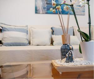 a table with a vase with flowers and a couch at Villa Braou in Rodakino