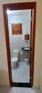 a bathroom with a toilet and a sink at Suíte das flores em Guajiru in Trairi +70 photos