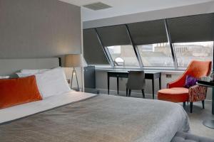 a bedroom with a bed and a desk and two chairs at Ten Hill Place, WorldHotels Distinctive in Edinburgh