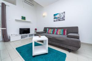 a living room with a couch and a tv at Apartments Du Lux 3 in Mokošica
