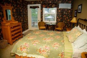 a bedroom with a bed, a chair, and a window at Sylvan Inn Bed & Breakfast in Glen Arbor
