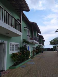 a green building with balconies and flowers on a street at Morada Felice in Bertioga