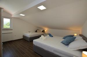 a bedroom with two beds and a window at Villa Sofia in Martinšćica