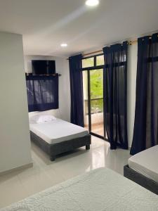 a bedroom with two beds and a window at Luna Cartagena Airport Hotel in Cartagena de Indias