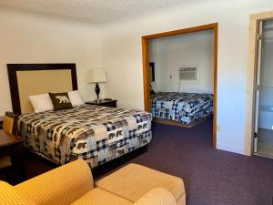 een hotelkamer met twee bedden en een bank bij Holiday Lodge in Cody +40 foto's