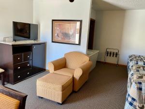 a living room with a chair and a tv at Holiday Lodge in Cody