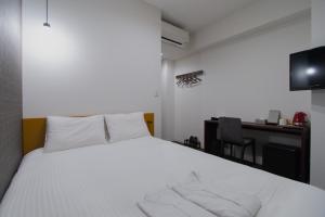 a bedroom with a white bed and a desk at Meldia Stay Omiya KARIGANE in Kyoto