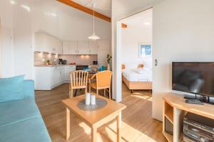 a living room with a couch and a table with a tv at Rügen Vilm mit Seeblick und Sonnenterasse in Ostseebad Sellin +43 photos