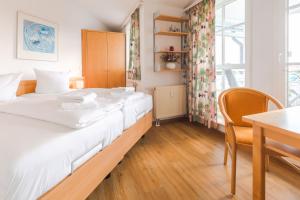 a large bed in a room with a table at Rügen Vilm mit Seeblick und Sonnenterasse in Ostseebad Sellin