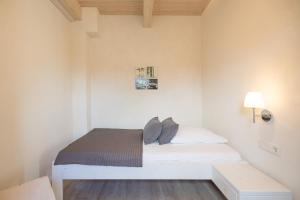 um pequeno quarto com uma cama branca num quarto em Ferienhaus Nordspitze em Dagebüll