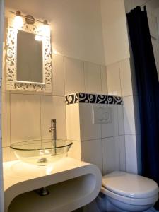 a bathroom with a glass sink and a toilet at Apartment Gartenstrasse 3 in Ostseebad Sellin