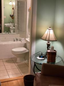 a bathroom with a toilet and a table with a lamp at Smugglers Notch Inn in Jeffersonville