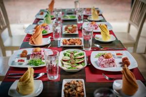 una mesa larga con platos de comida. en The Backwaters Lodge, en Wilpattu