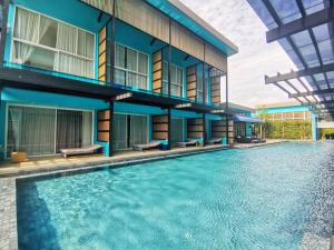 un hotel con piscina di fronte a un edificio di Beach Walk Boutique Resort a Bangsaen