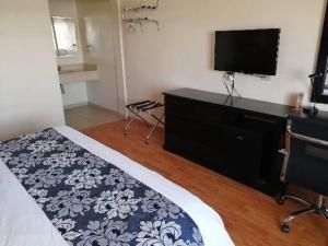 um quarto com uma cama e uma televisão de ecrã plano em Hotel Express Inn em Sabinas