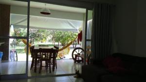 a living room with a table and chairs and a sliding glass door at Imbassaí in Imbassai