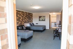 a bedroom with two beds and a table and a kitchen at Highway Inn Motel in Hay