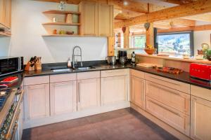 a kitchen with wooden cabinets and a sink at Chalet Musini - OVO Network in Le Grand-Bornand