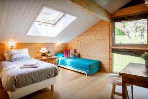 a bedroom with a bed and a window in a attic at Chalet Musini - OVO Network in Le Grand-Bornand