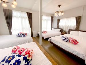 a hotel room with two beds and a mirror at TABISAI HOTEL House 博多 in Fukuoka