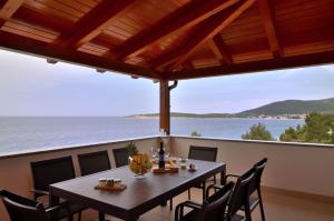 a table on a balcony with a view of the ocean at Apartments Villa Sofia in Martinšćica