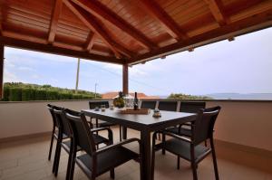 a dining room with a table and chairs on a balcony at Apartments Villa Sofia in Martinšćica