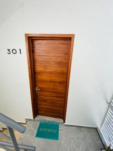 una puerta de madera en una habitación con un cartel delante en Centrico Departamento (301), en Cancún