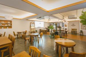 a restaurant with wooden tables and chairs and a room at Brown-Dot Hotel Choeup in Busan