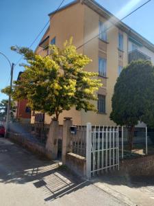 a tree in front of a building with a fence at FLY HOUSE BOLOGNA...un appartamento al volo in Bologna