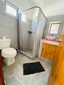 y baño con aseo, lavabo y ducha. en Centrico Departamento 201 en Cancún